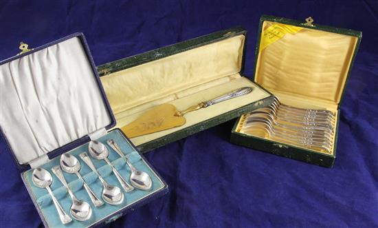 A cased set of twelve French plated teaspoons, a French silver handled cake slice and a cased set of six plated teaspoons.